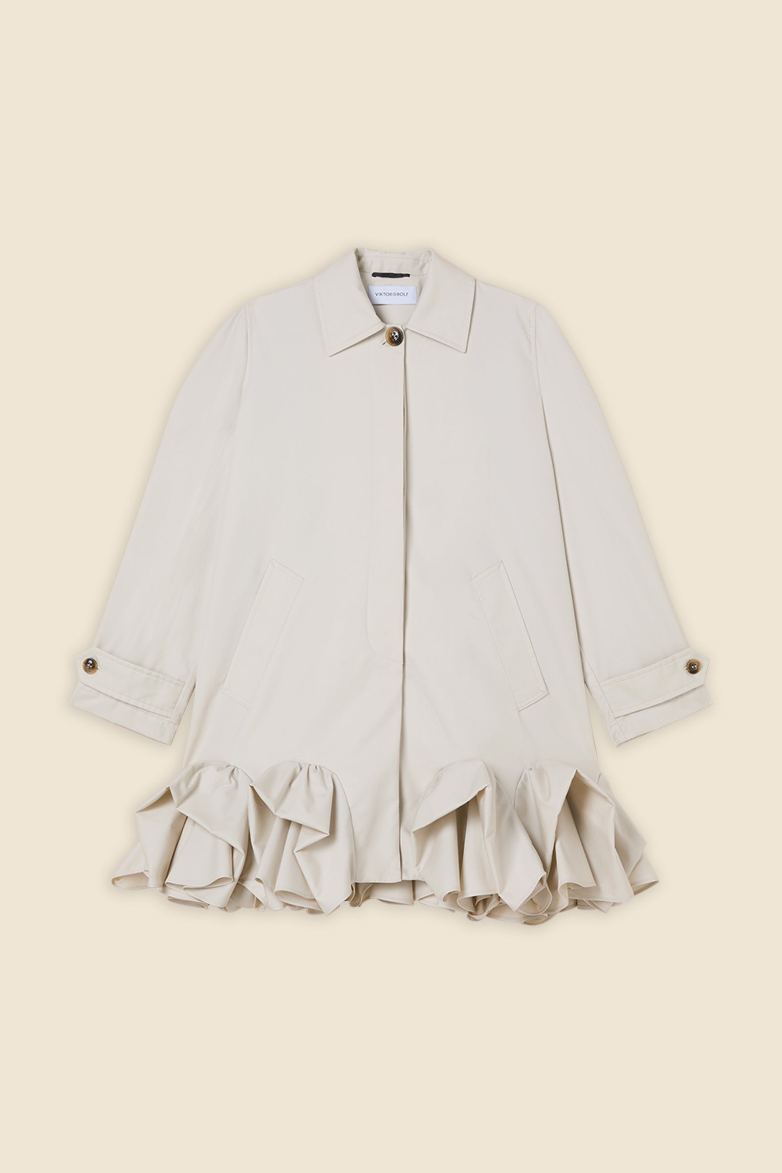 The craftmanship of the trenchcoat reinterprets classic haute couture tuck ups into a modern silhouette from gabardine