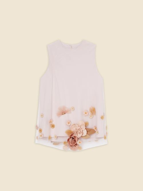 Sleeveless white blouse with peach floral 3D appliqués at the hem, offering a delicate and elegant feminine touch.