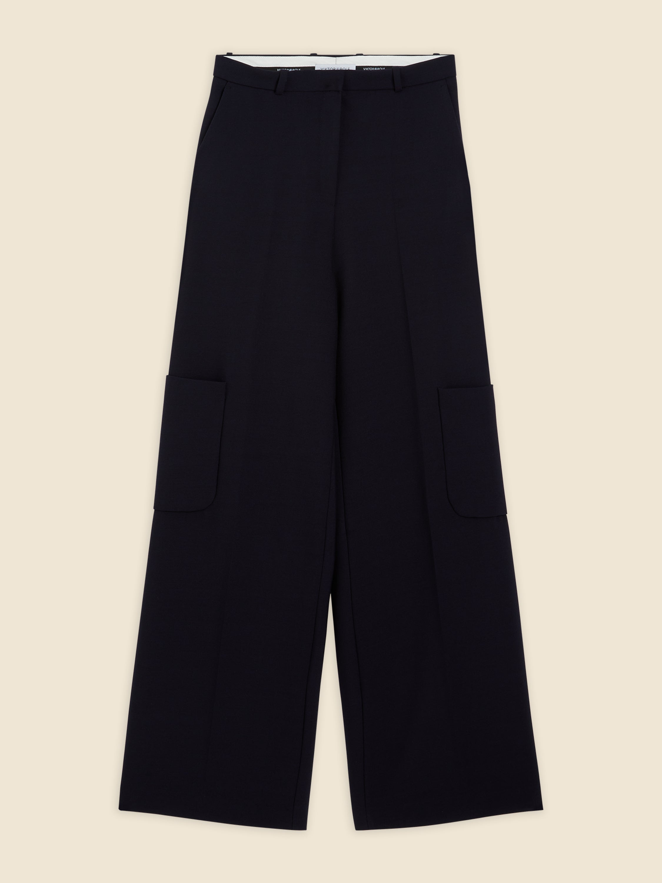 Wide-leg black trousers featuring large utility pockets, crafted from luxurious wool with a subtle crease along the front.