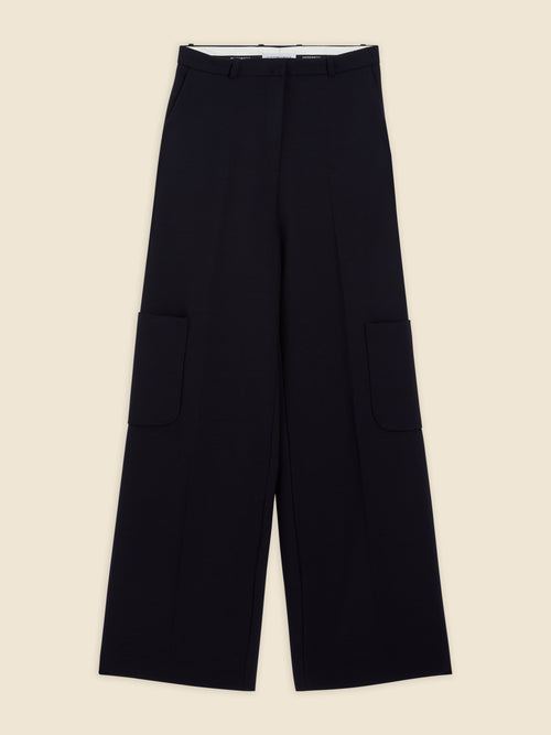 Wide-leg black trousers featuring large utility pockets, crafted from luxurious wool with a subtle crease along the front.