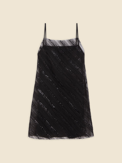 Black spaghetti strap dress with diagonal sequin stripes on sheer fabric, creating a stylish and elegant look.