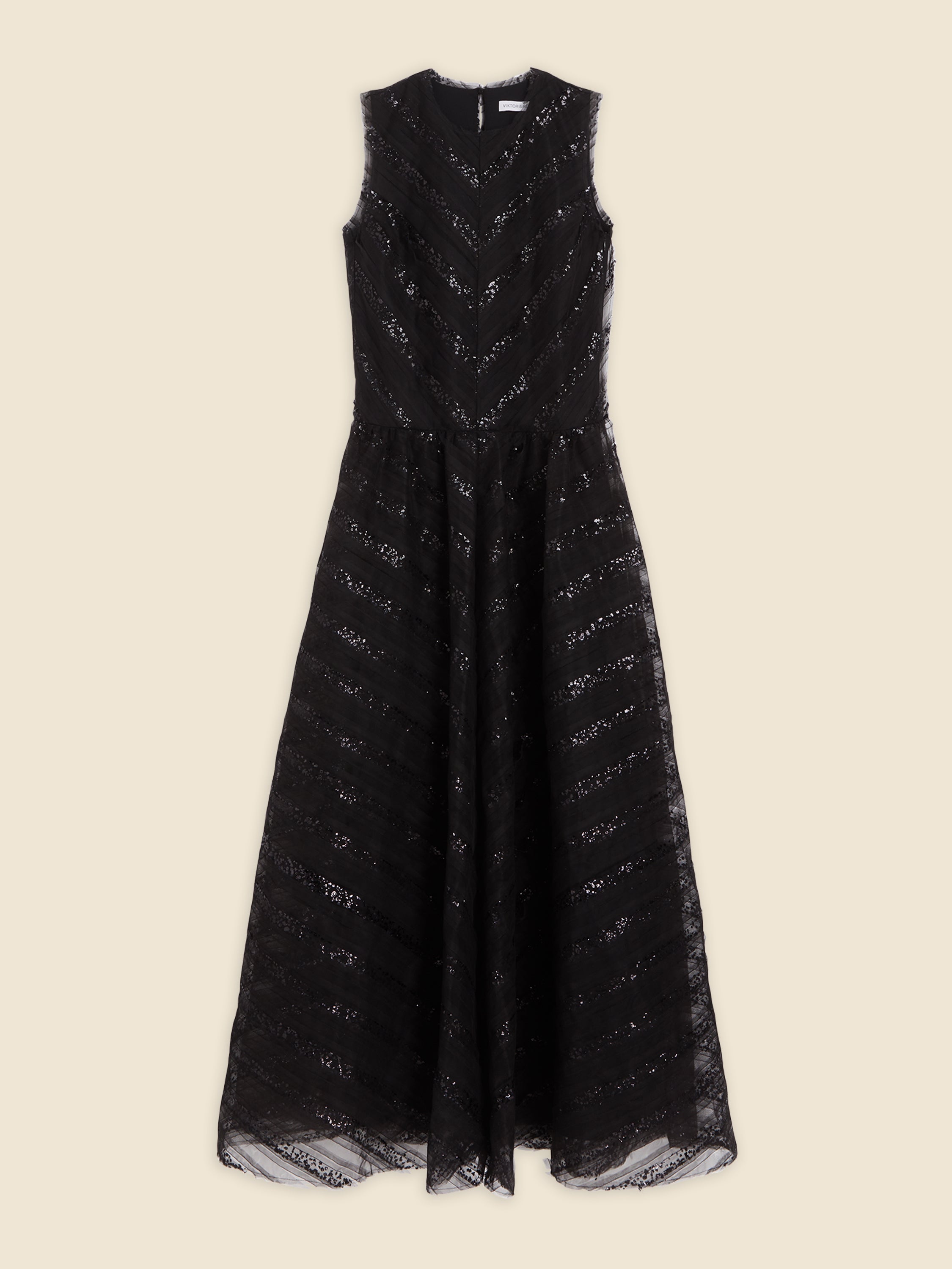 Elegant black sleeveless lace dress with chevron pattern, featuring a fitted bodice and flowing skirt on a beige backdrop.