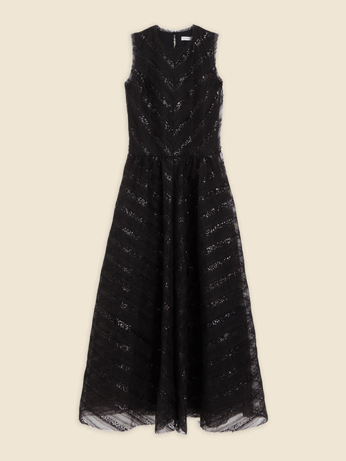 Elegant black sleeveless lace dress with chevron pattern, featuring a fitted bodice and flowing skirt on a beige backdrop.