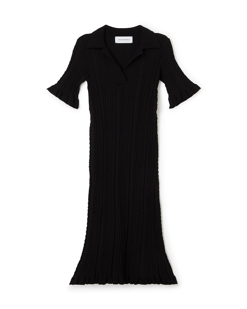 Elegant black ribbed knit dress with flared sleeves and collar, featuring intricate textured patterns for stylish sophistication.