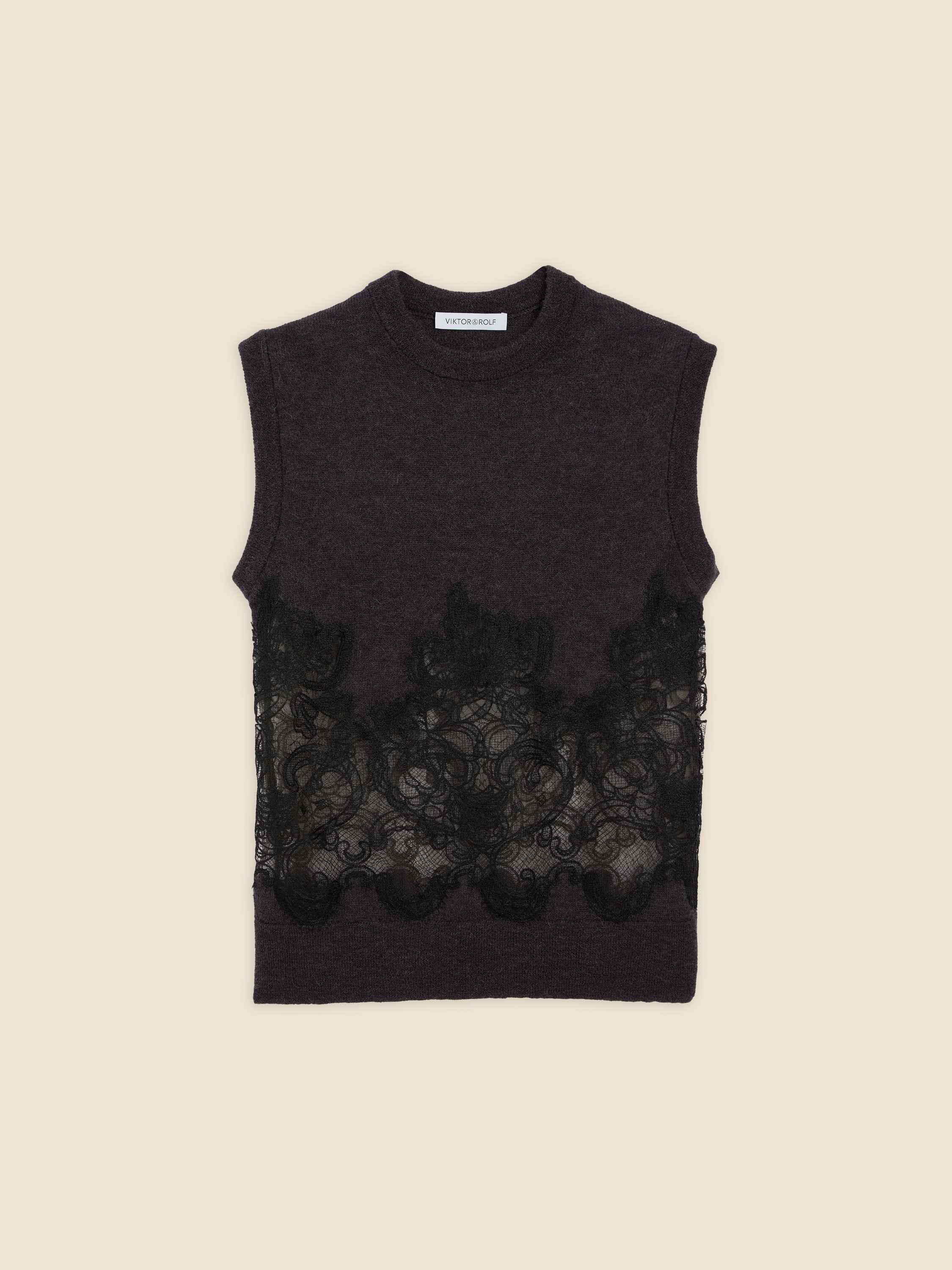 Sleeveless dark gray knit top with intricate black lace overlay, featuring a high neckline and refined craftsmanship.