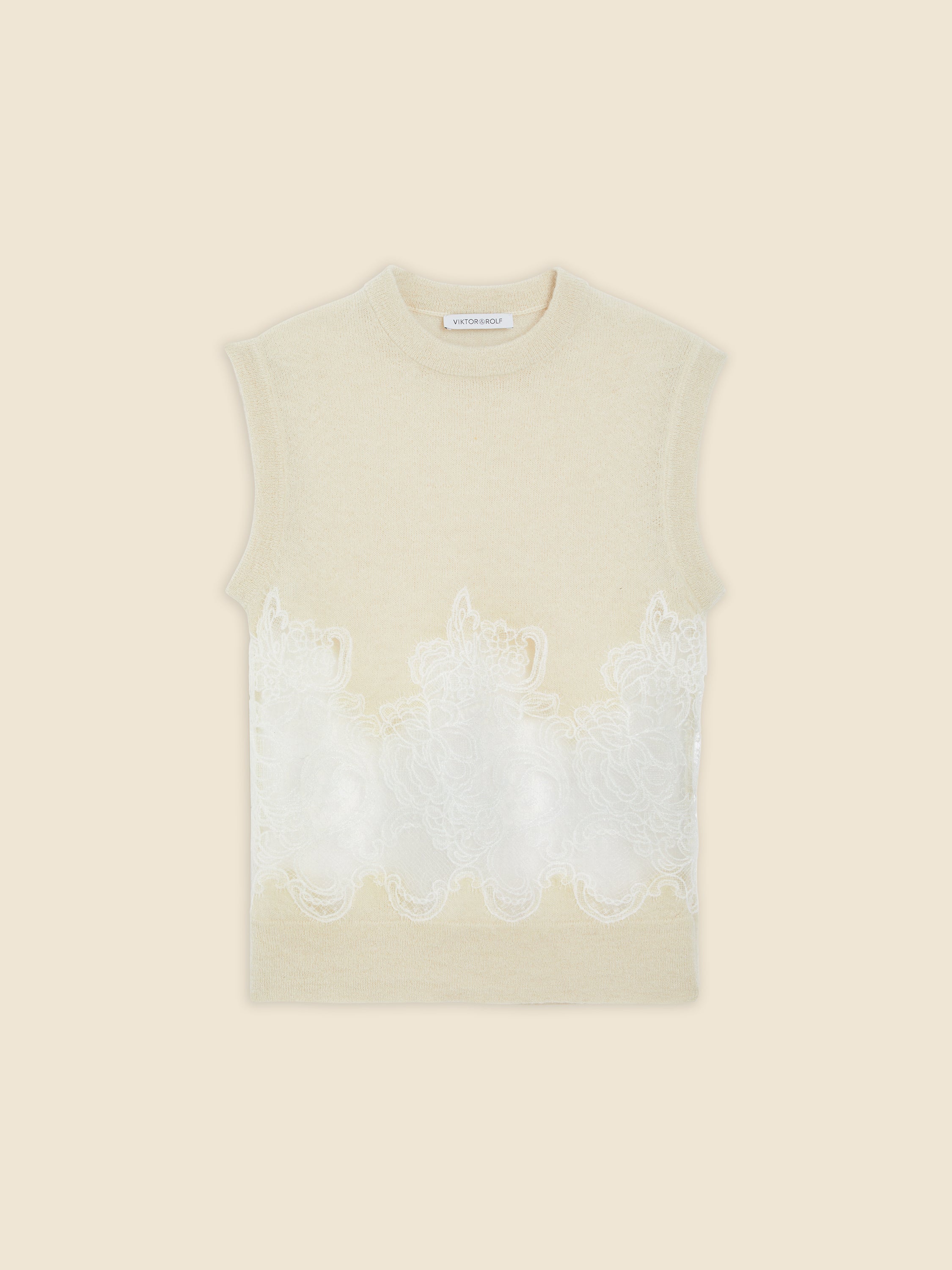 Sleeveless cream top featuring intricate floral lace embroidery across the midsection, adding elegance and texture.