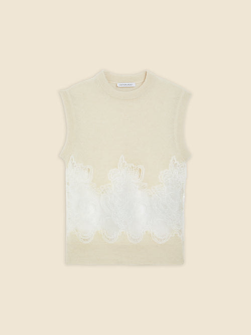 Sleeveless cream top featuring intricate floral lace embroidery across the midsection, adding elegance and texture.