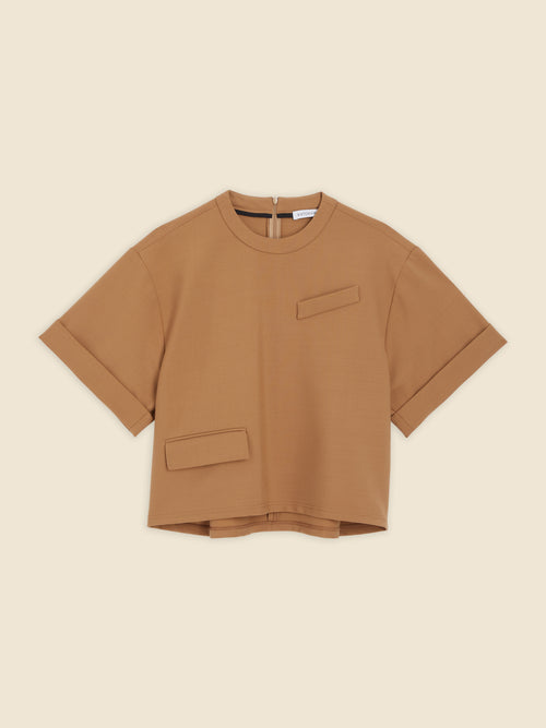 Boxy tan brown top with short sleeves, featuring unique pocket details and a subtle back zipper, crafted from soft material.