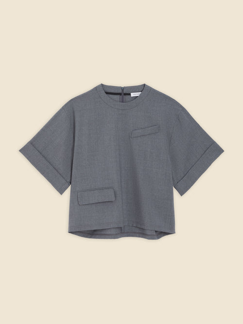 Gray linen blend top with short sleeves and minimalist pocket details, featuring a boxy silhouette and back zipper closure.