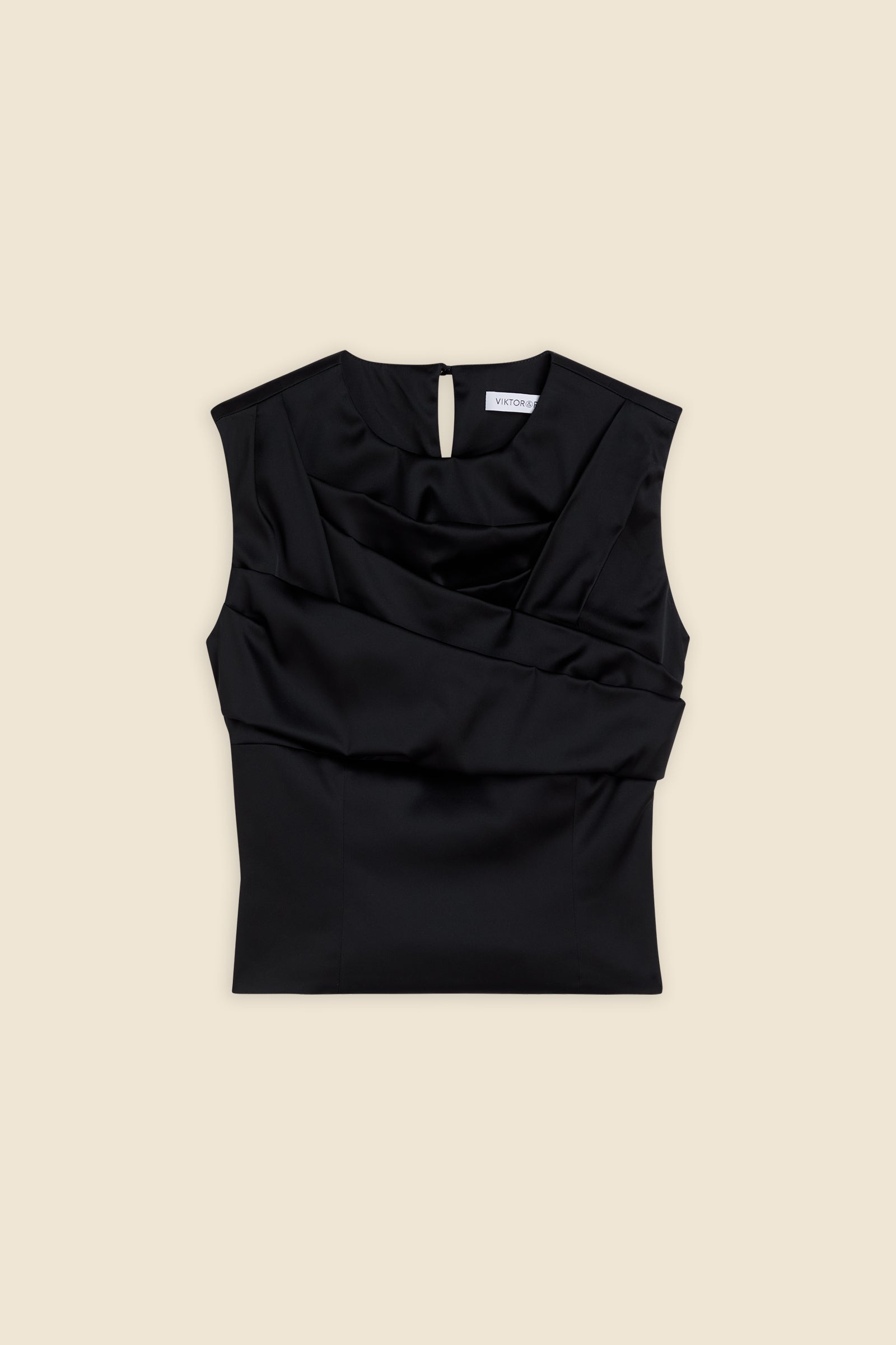 The meticulously placed pleats and stretch satin define the elegance of the top, reflecting classic haute couture craftsmanship with a modern edge