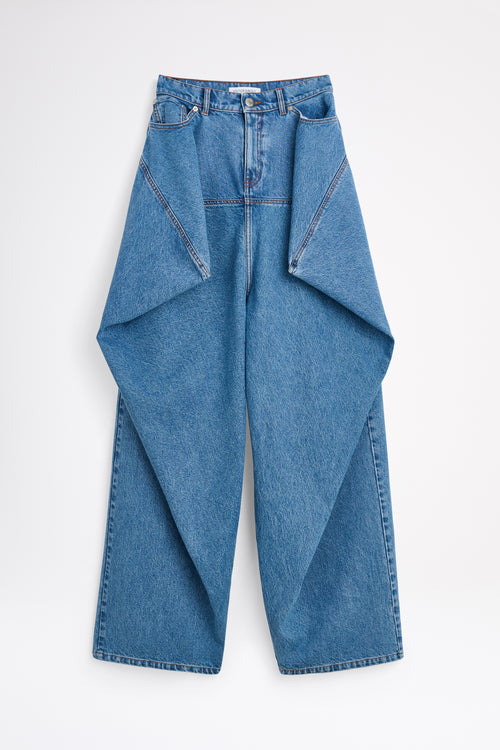 Woman wearing a burgundy top and blue jeans on a white background