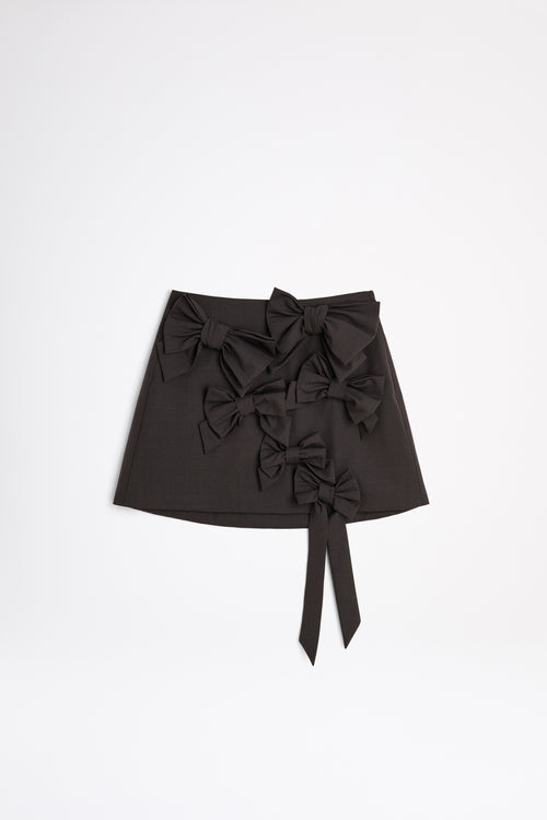 The wool skirt features the seasonal bow bouquet technique, where timeless elegance meets refined craftsmanship in a seamless fusion of sophistication and grace