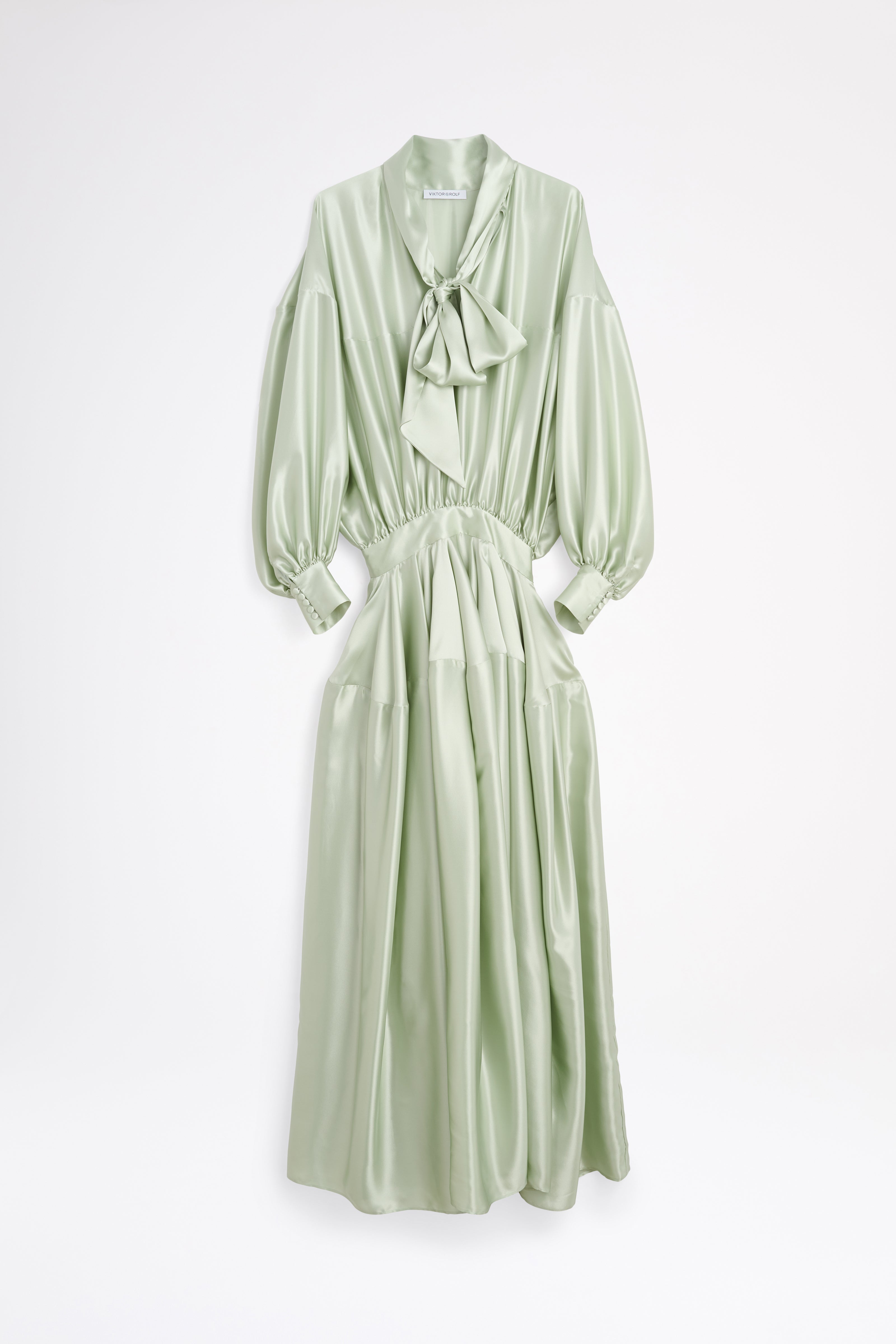 Light green dress with a bow detail on a white background