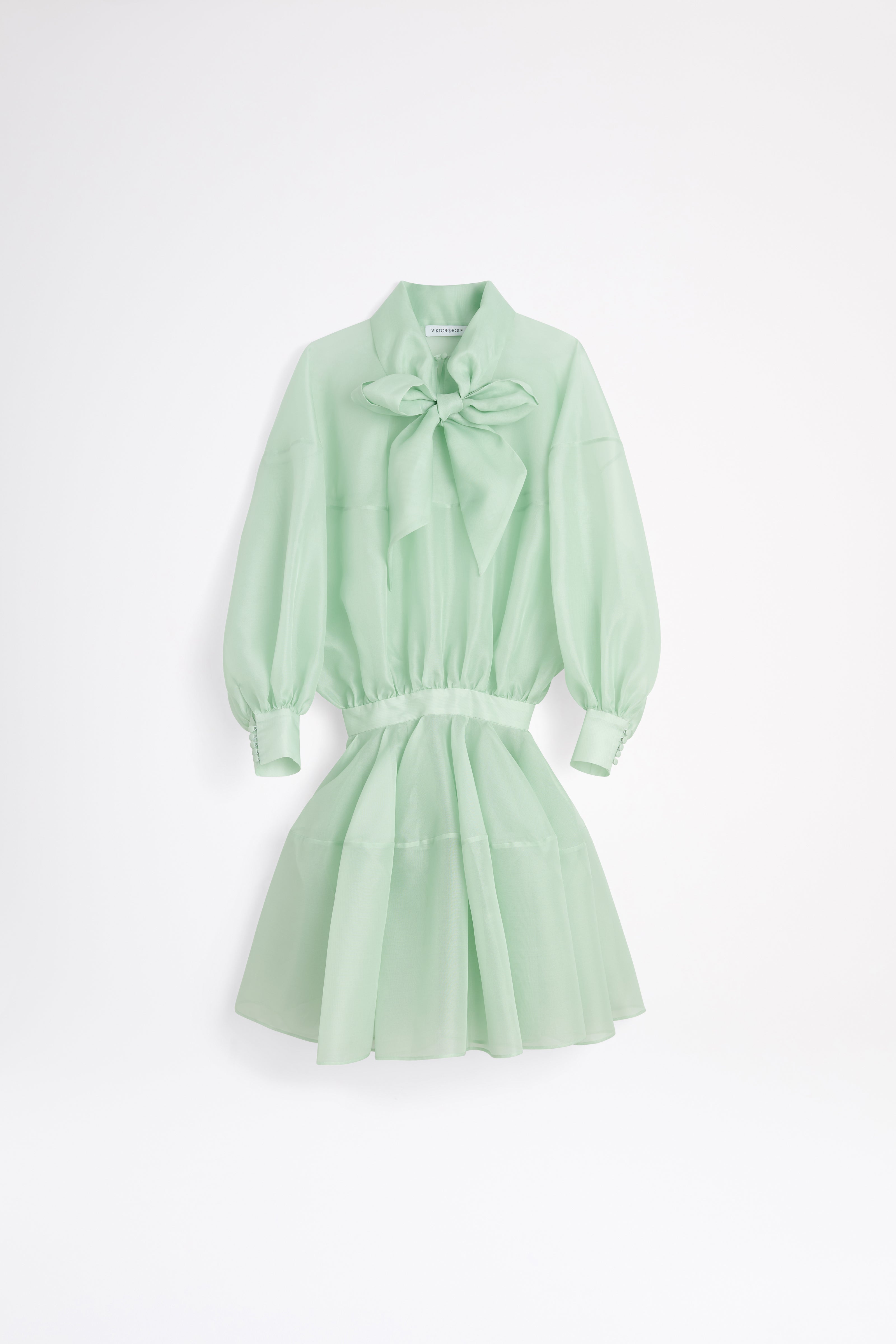 Light green dress with a bow detail on a white background