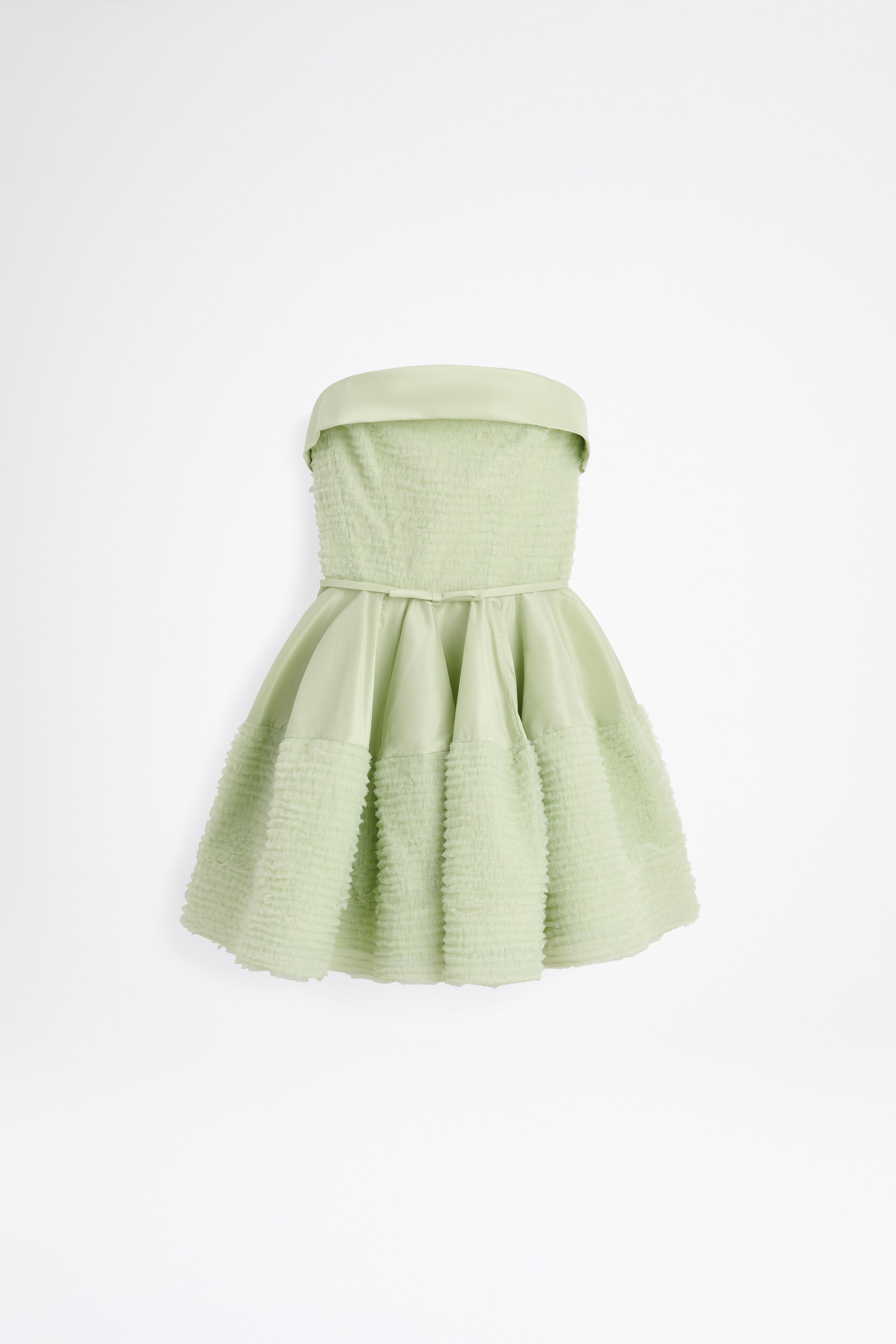 Light green strapless dress with pleated skirt on a white background