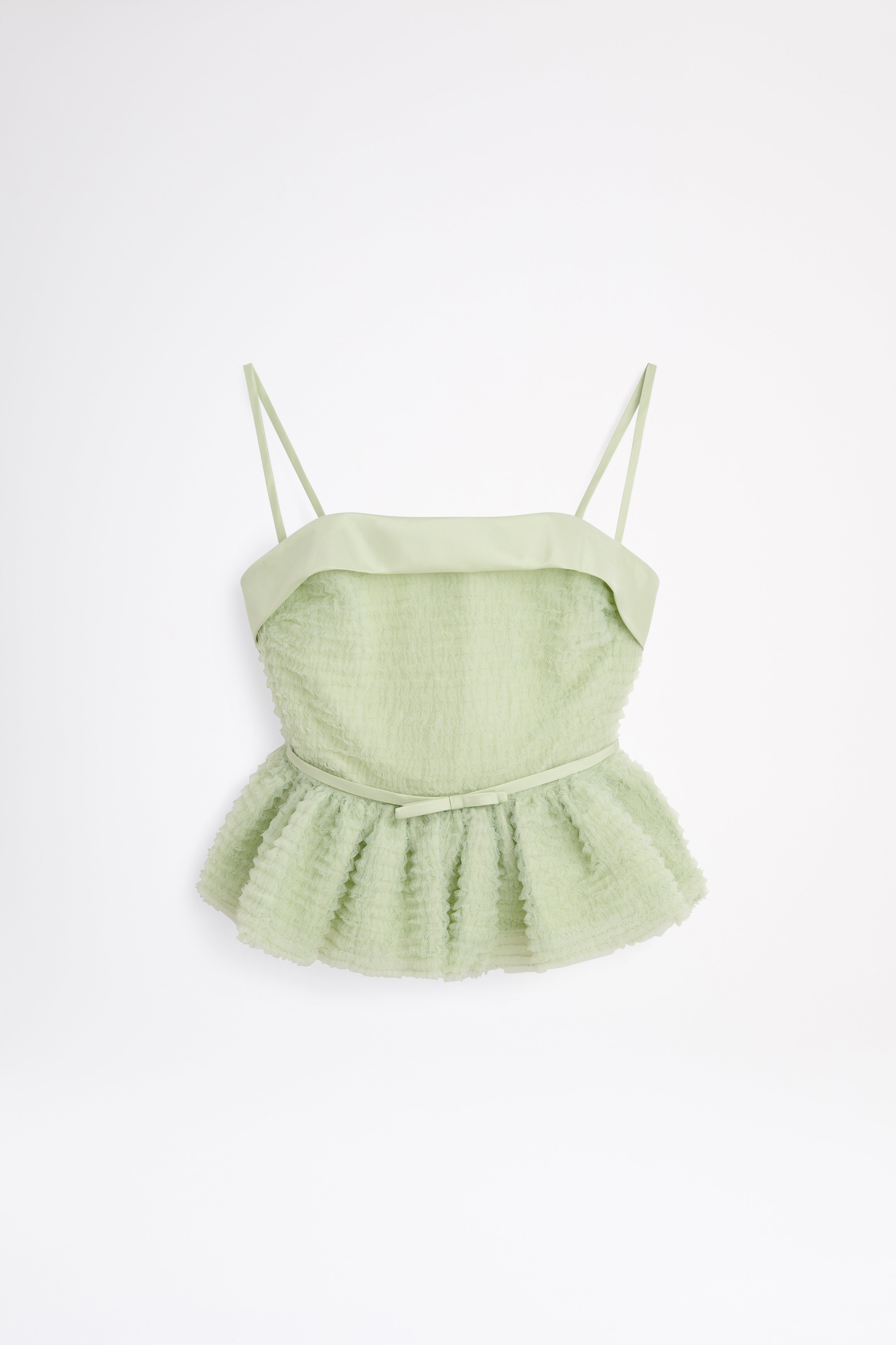 Light green peplum top with thin straps on a white background