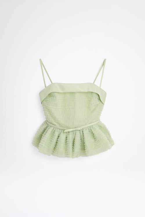 Light green peplum top with thin straps on a white background