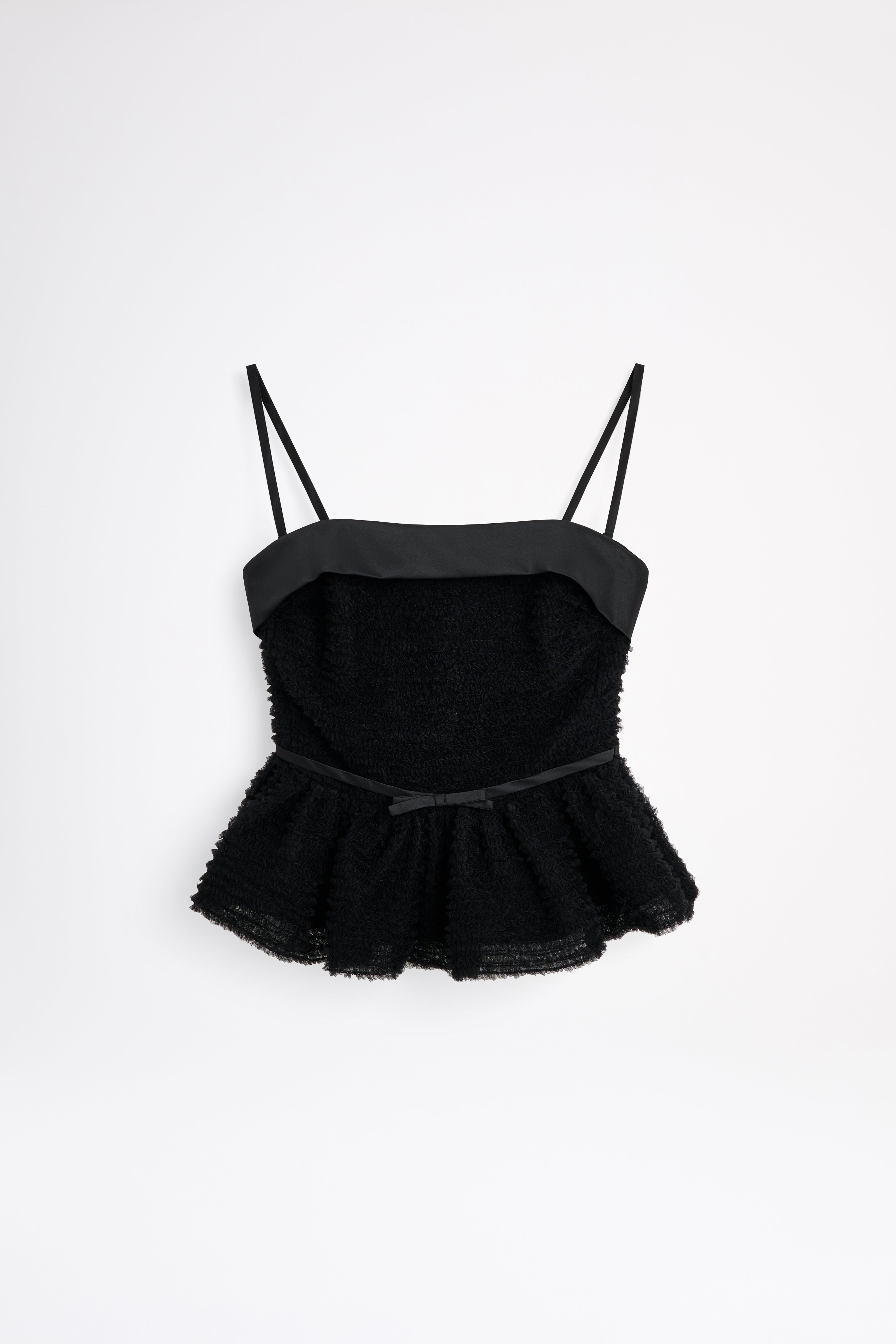 Black peplum top with thin straps on a white background