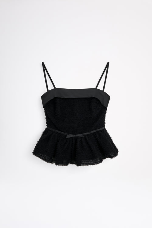Black peplum top with thin straps on a white background