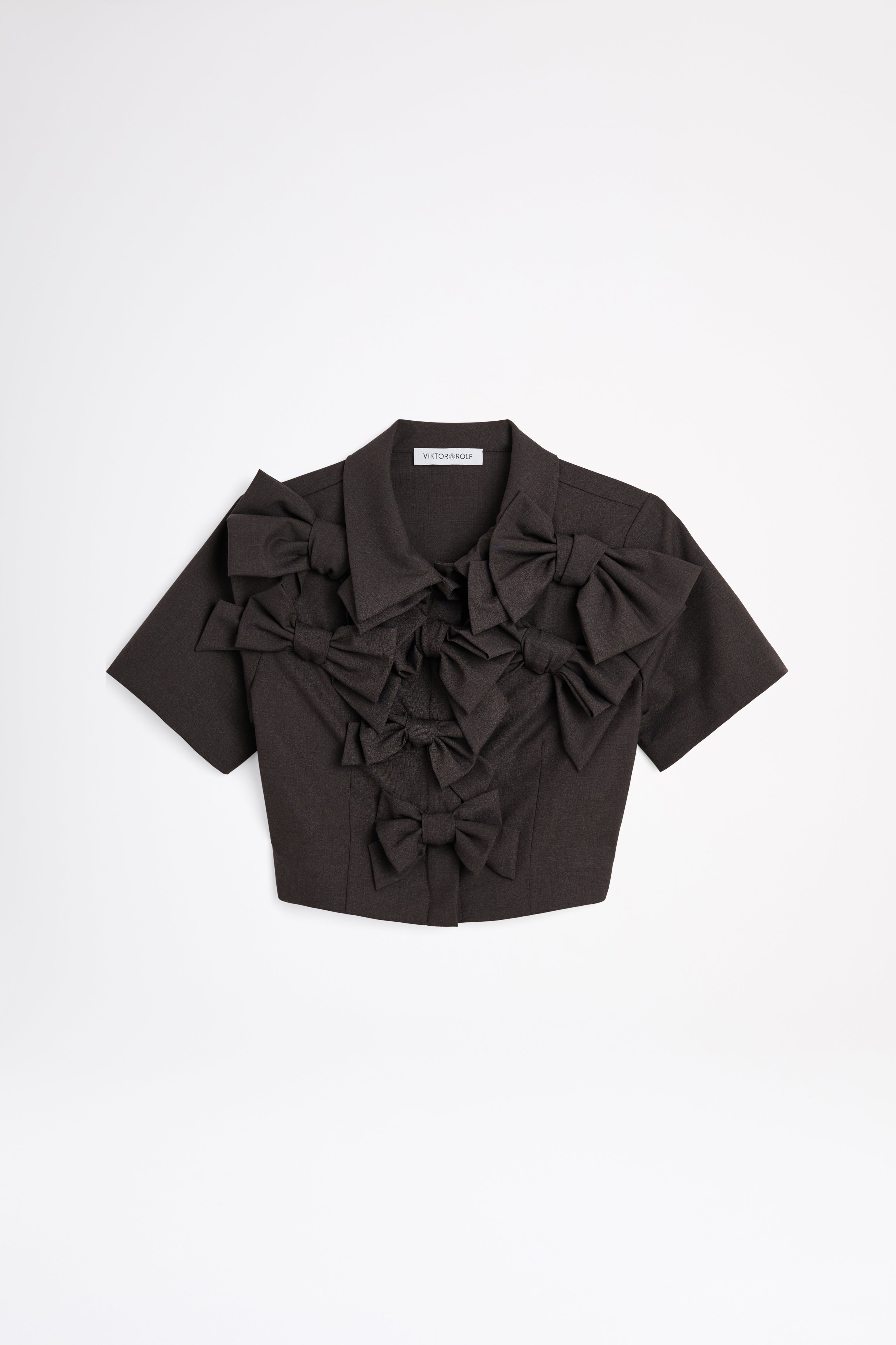 The wool top features the seasonal bow bouquet technique, where timeless elegance meets refined craftsmanship in a seamless fusion of sophistication and grace