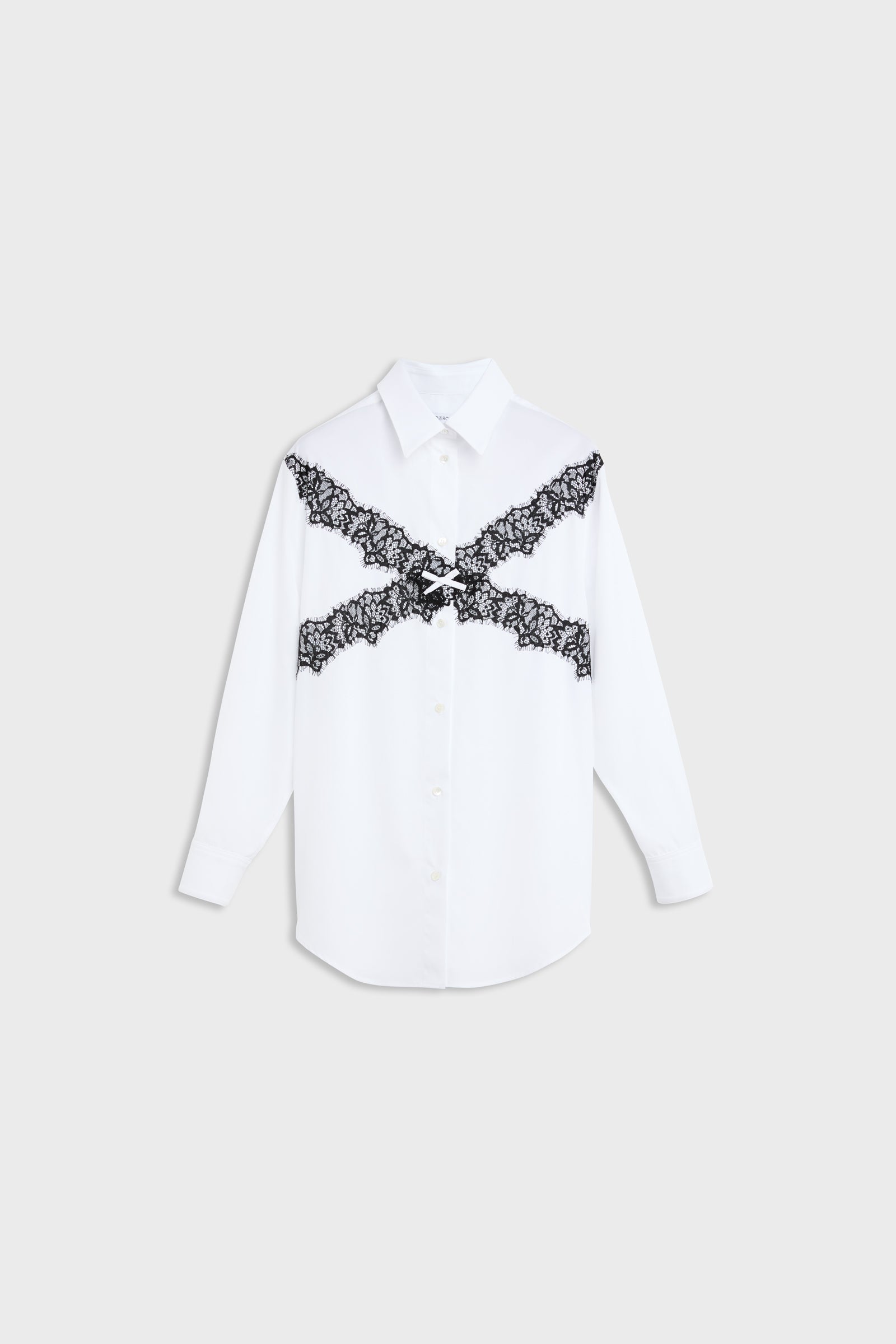 A white long-sleeve button-up shirt with a black lace X-shaped graphic across the chest, displayed flat against a light gray background.