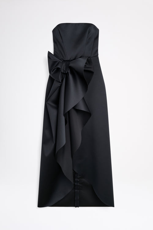 A satin black gown with a bow on a white background.