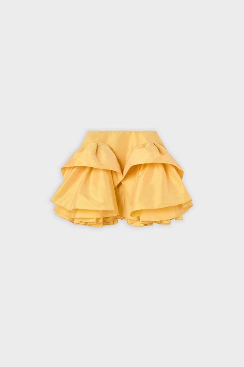 A yellow ruffled skirt on a white background.