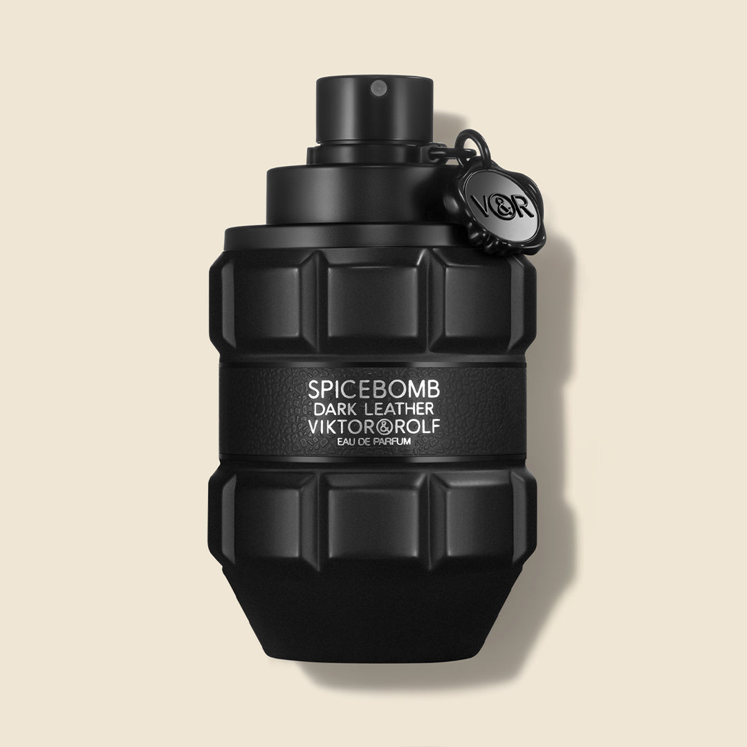Black grenade-shaped perfume bottle with embossed logo detailing, designed with a sleek matte finish for a bold, edgy appeal.