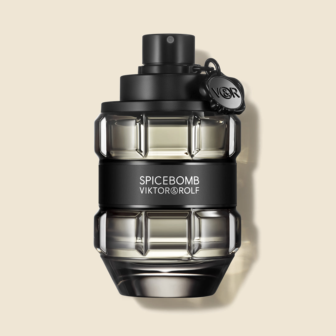 Elegant grenade-shaped bottle of Viktor & Rolf Spicebomb fragrance with a sleek black cap and label on a beige backdrop.