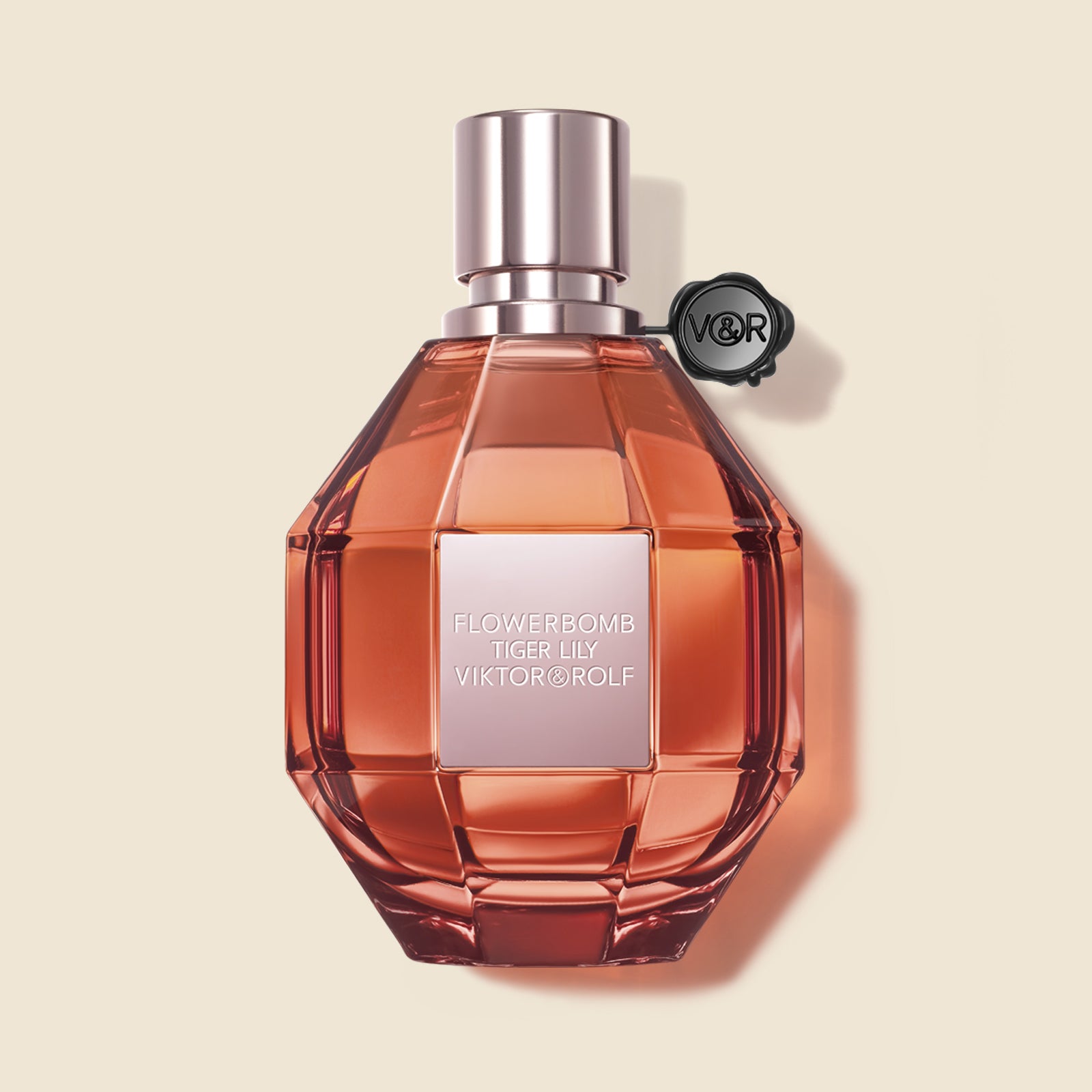 A faceted bottle of Flowerbomb Tiger Lily Eau de Parfum by Viktor & Rolf, in amber tones, exuding a floral aroma for women.