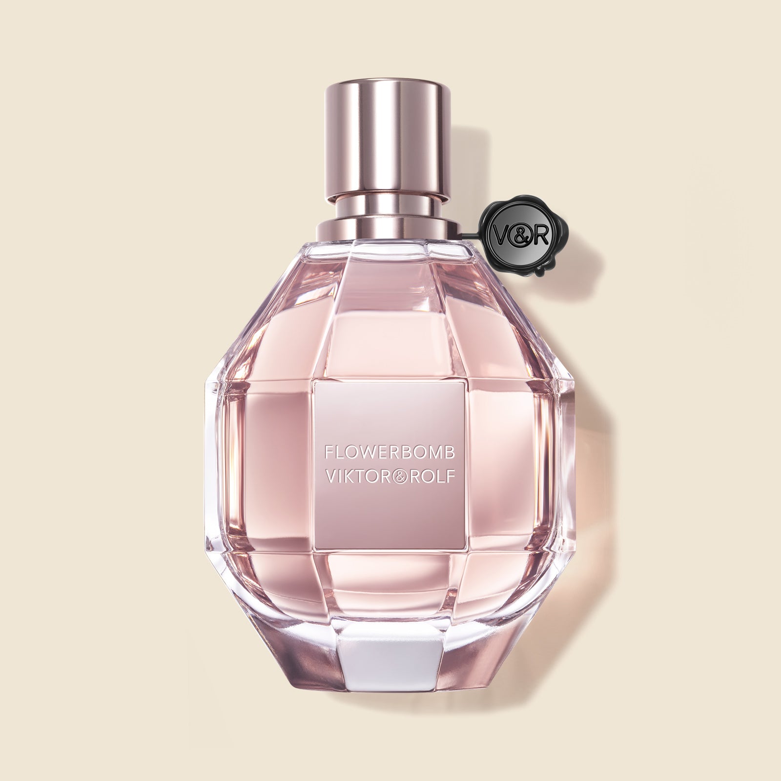 A feminine, diamond-cut glass bottle of Flowerbomb by Viktor & Rolf, featuring a blush pink fragrance for women with floral notes.