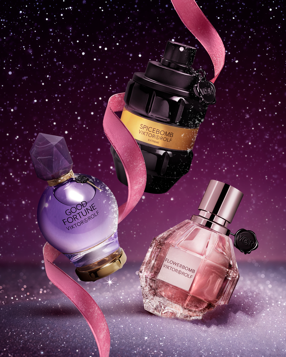 Three perfume bottles with ribbons against a starry night sky background