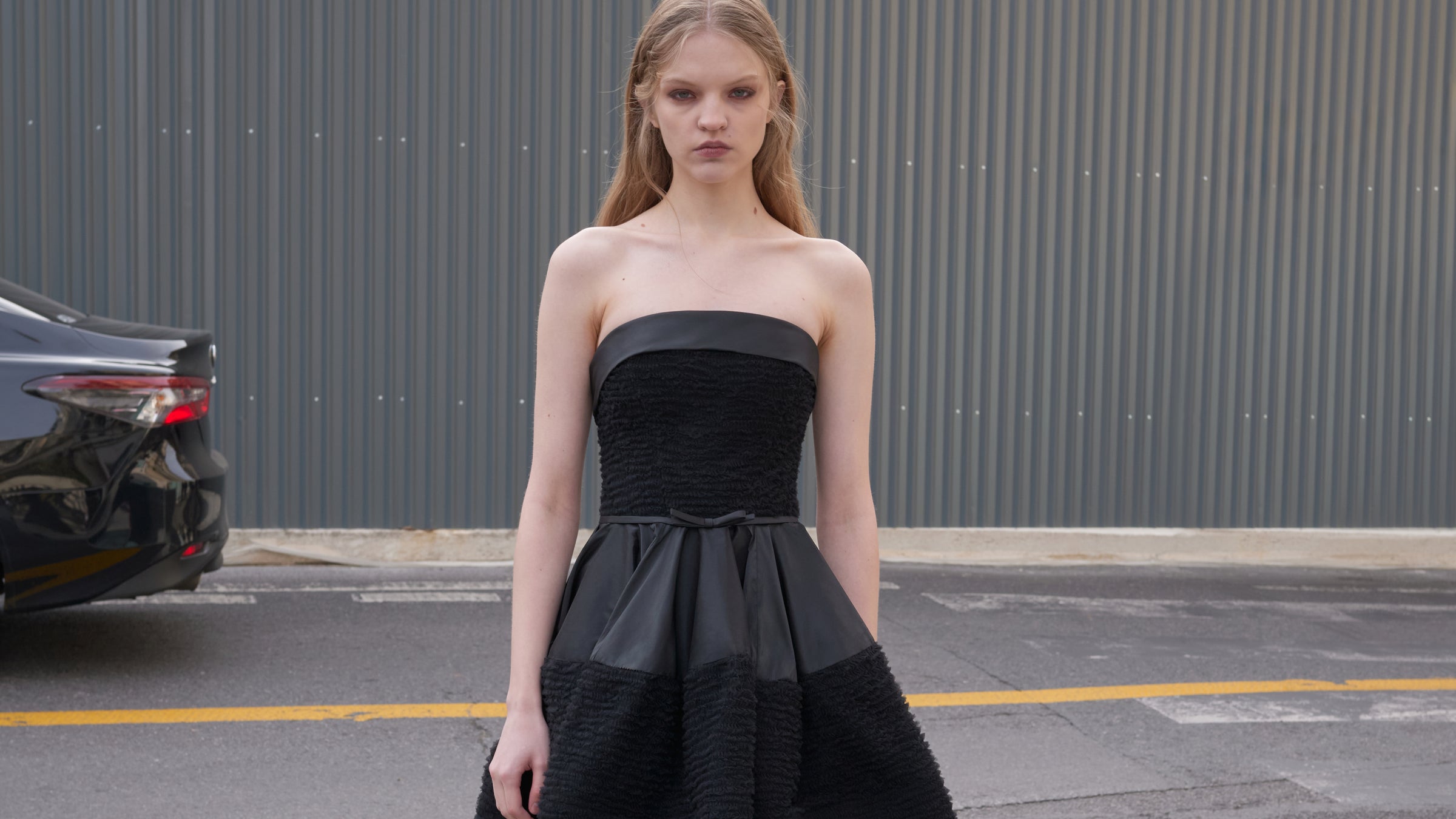 Model wearing a black tulle mini dress outside.