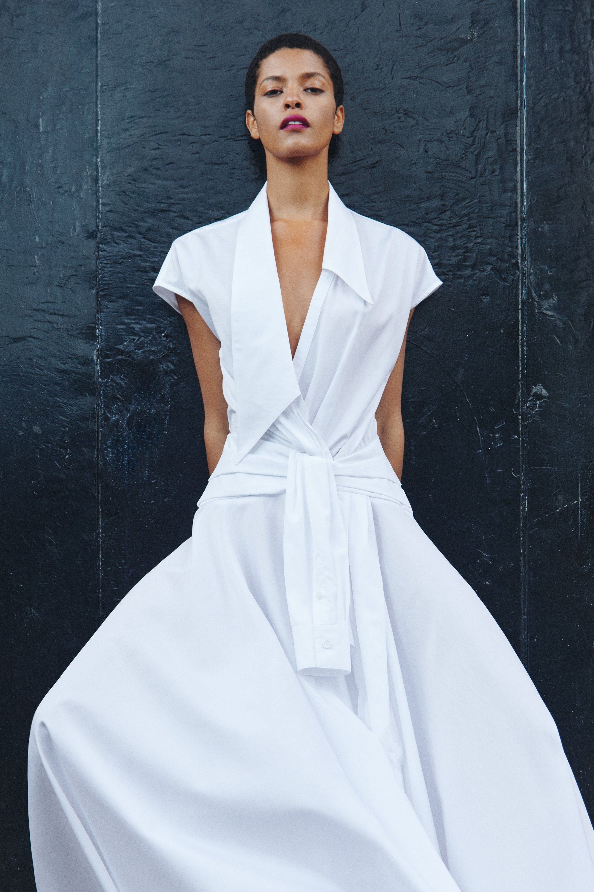 Woman wearing a white dress against a dark background