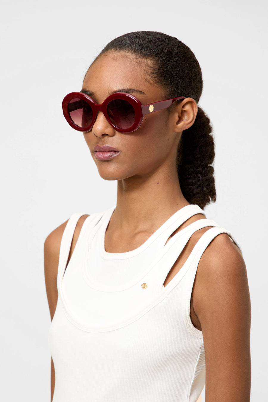 Model wearing burgundy round glasses.