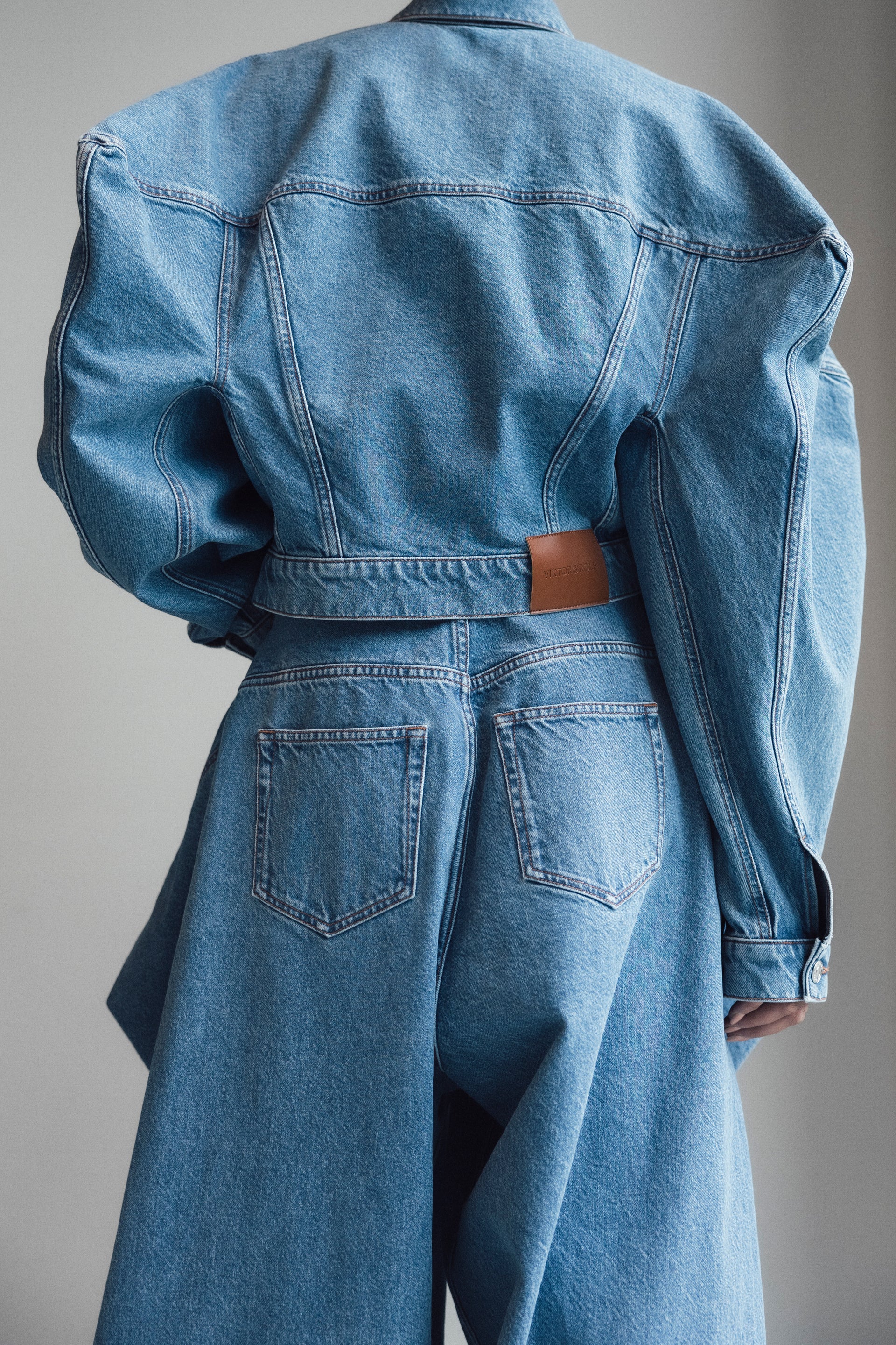 Blue denim jacket and pants worn by a person on a plain background