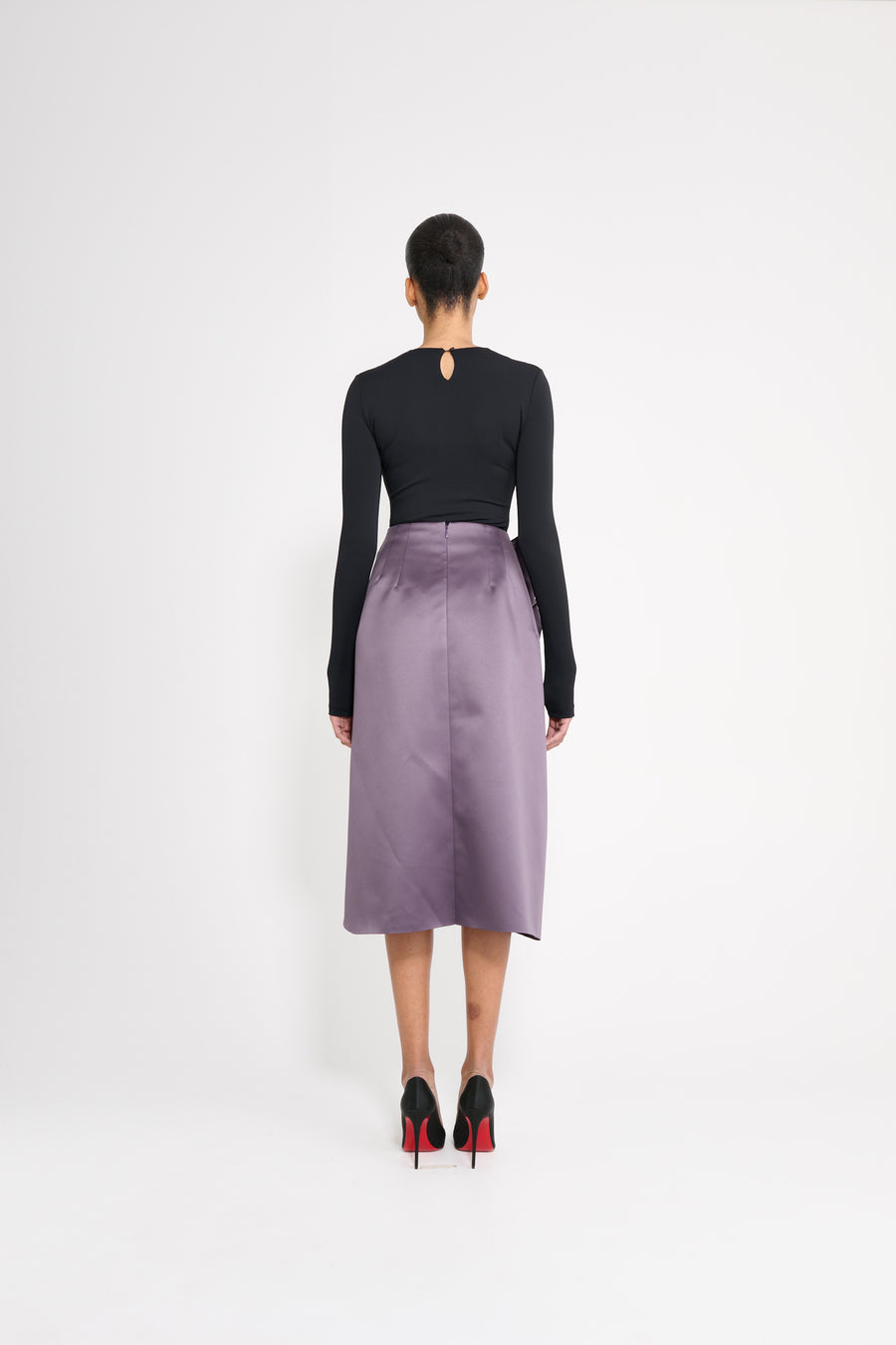 Model wearing a black drape body with a purple satin skirt. 