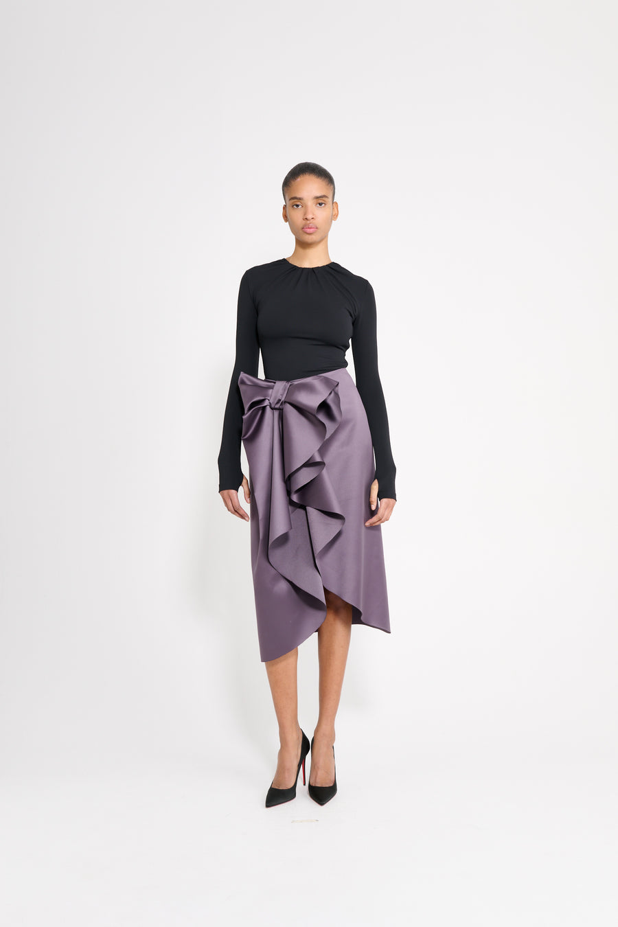 Model wearing a black drape body with a purple satin skirt.