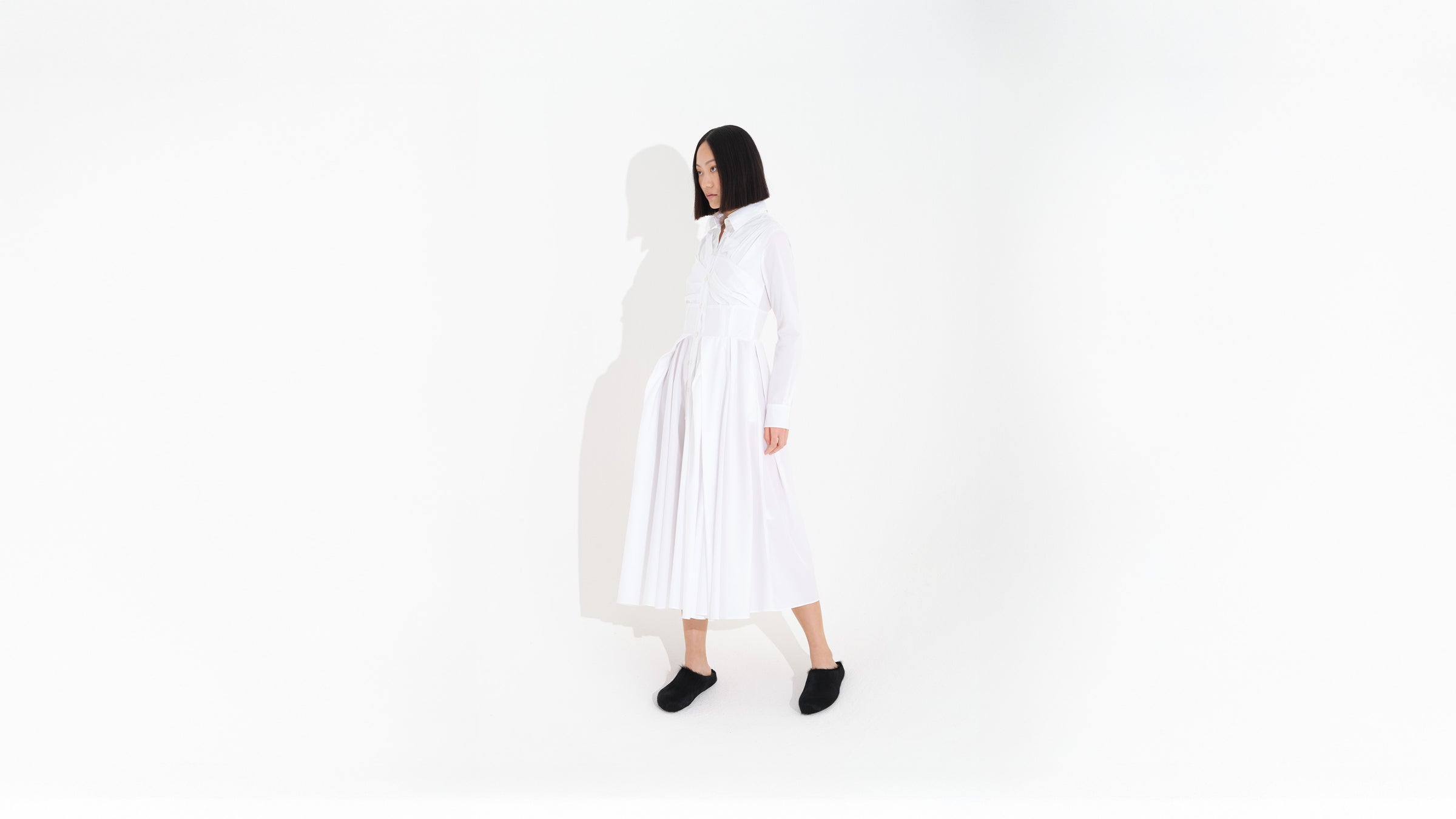 Person wearing a long white dress on a white background