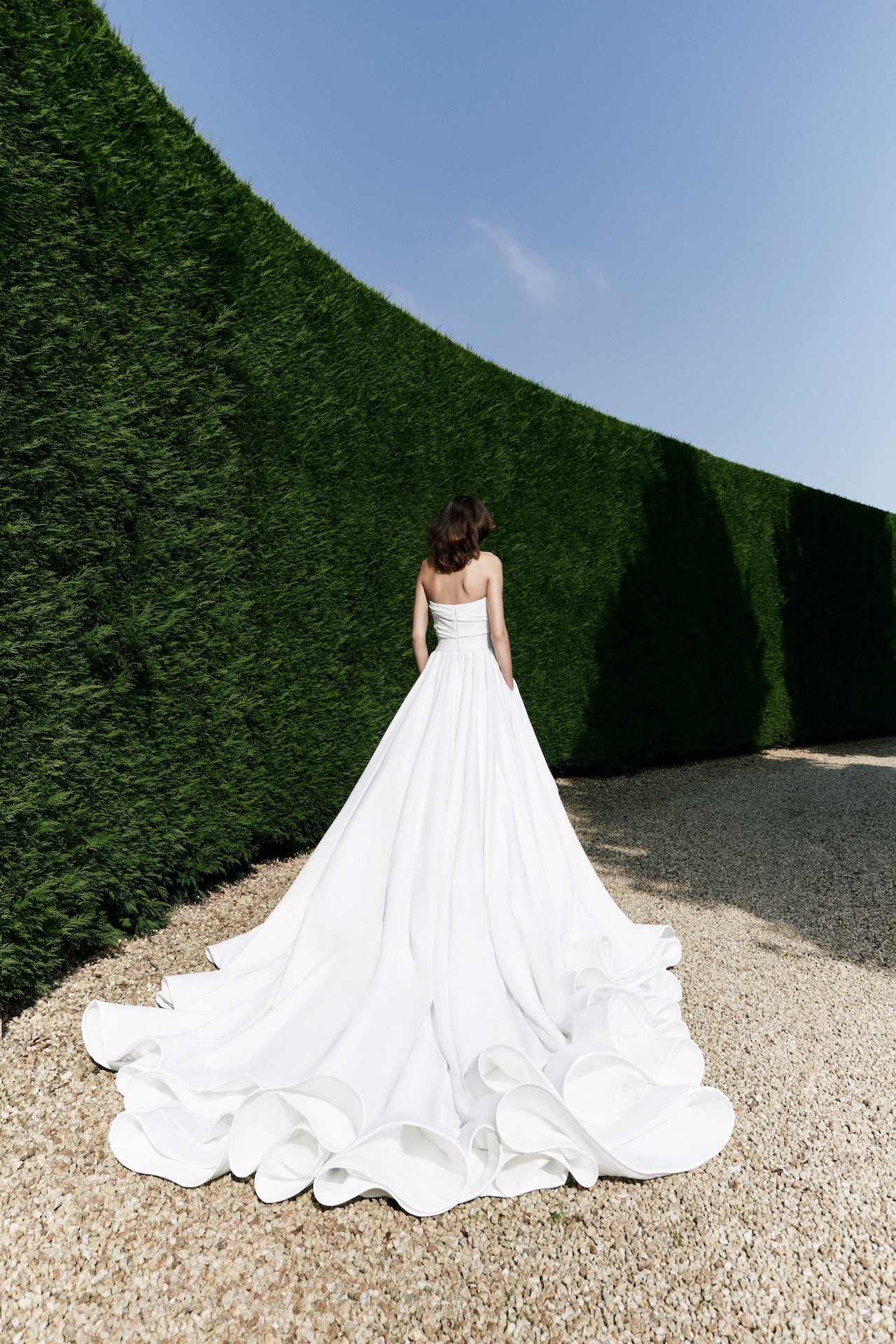Viktor & Rolf Mariage Bridalwear Autumn Winter 25 Collection, elegant white gown, sophisticated design with flowing train.