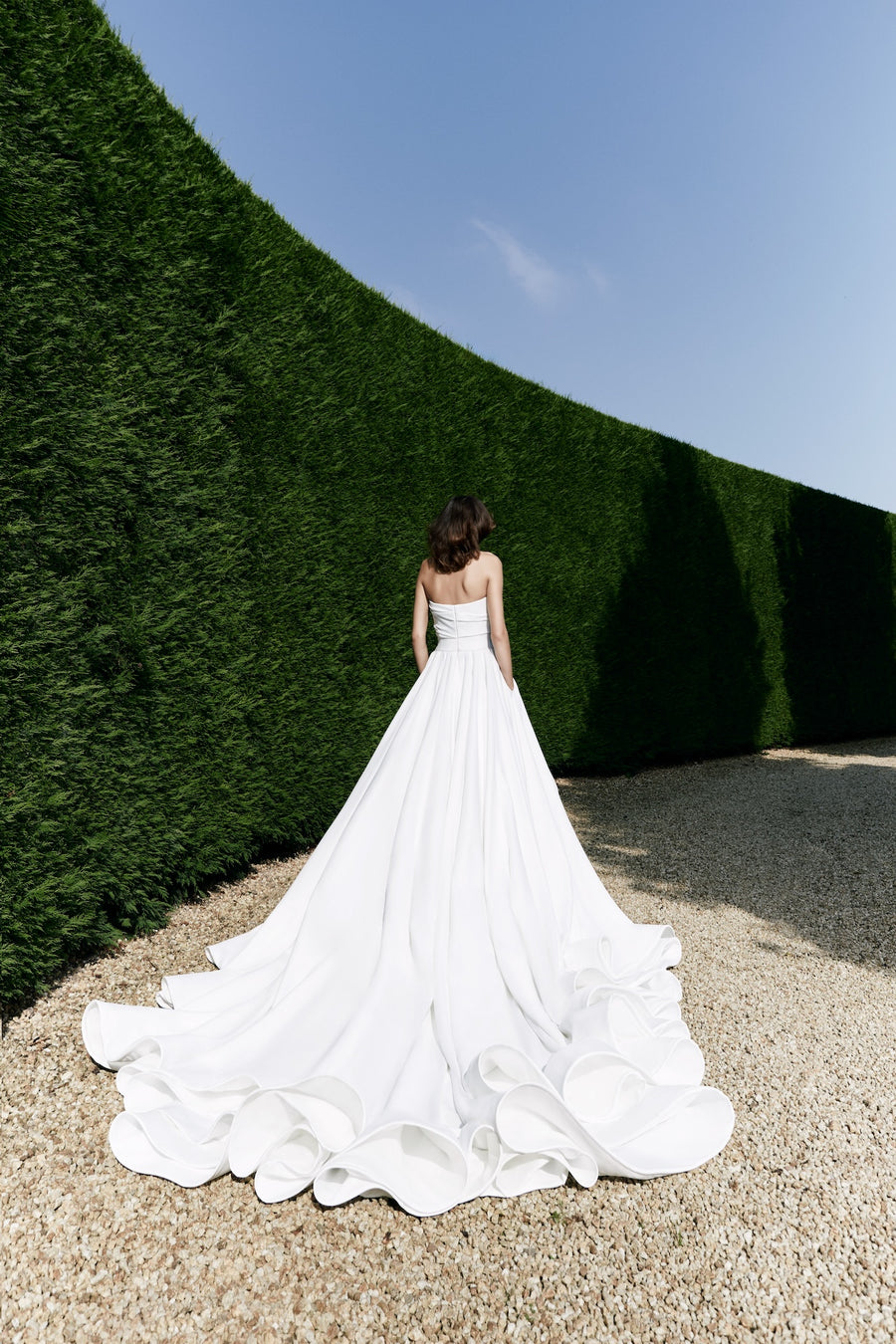 Viktor & Rolf Mariage Bridalwear Autumn Winter 25 Collection, elegant white gown, sophisticated design with flowing train.