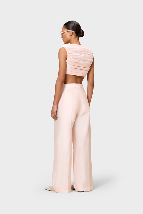 Model wearing a pink satin set on a white background.