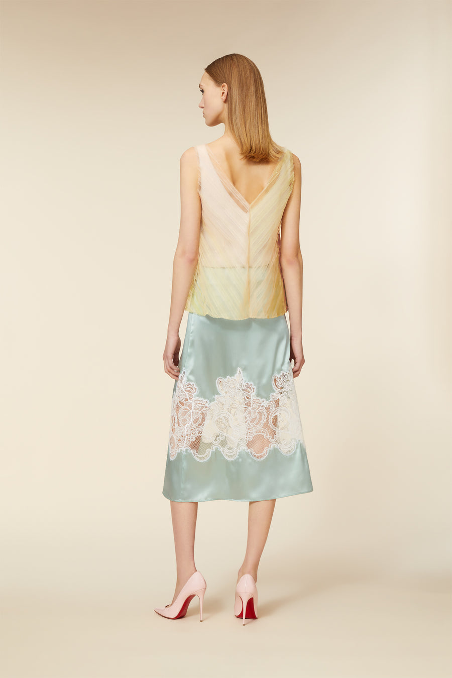 Elegant dress with delicate pastel chiffon top and scalloped lace detailing over a silky aqua skirt, paired with pink heels.