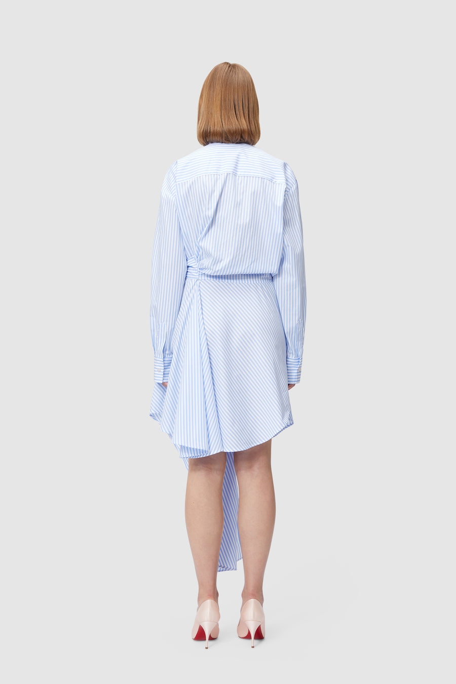 Asymmetrical shirt dress with blue and white stripes, featuring a flowing draped hem and long cuffed sleeves.