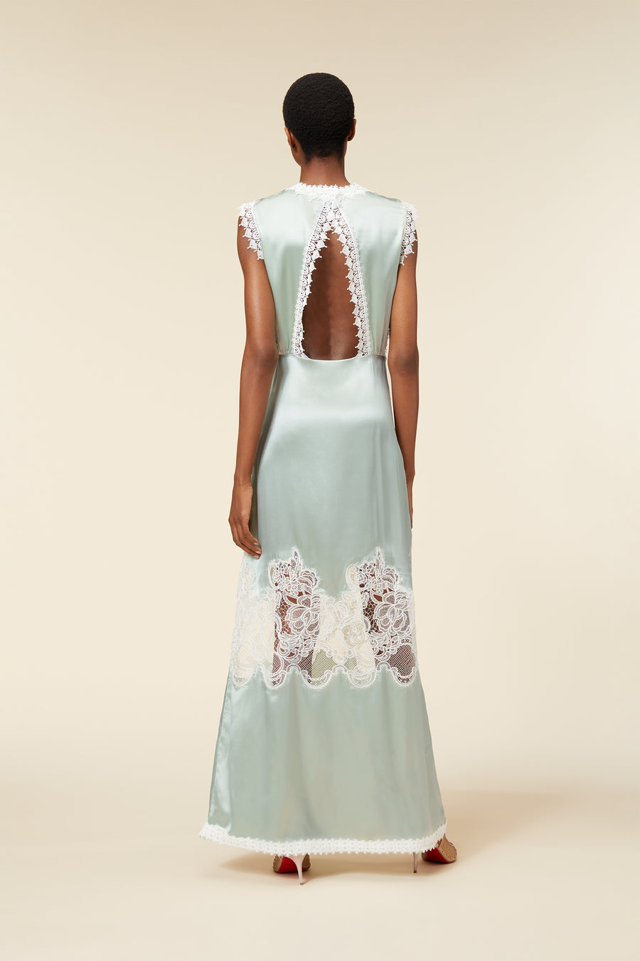 Elegant sky-blue satin gown with intricate white lace detailing and open back design, showcasing chic evening attire.