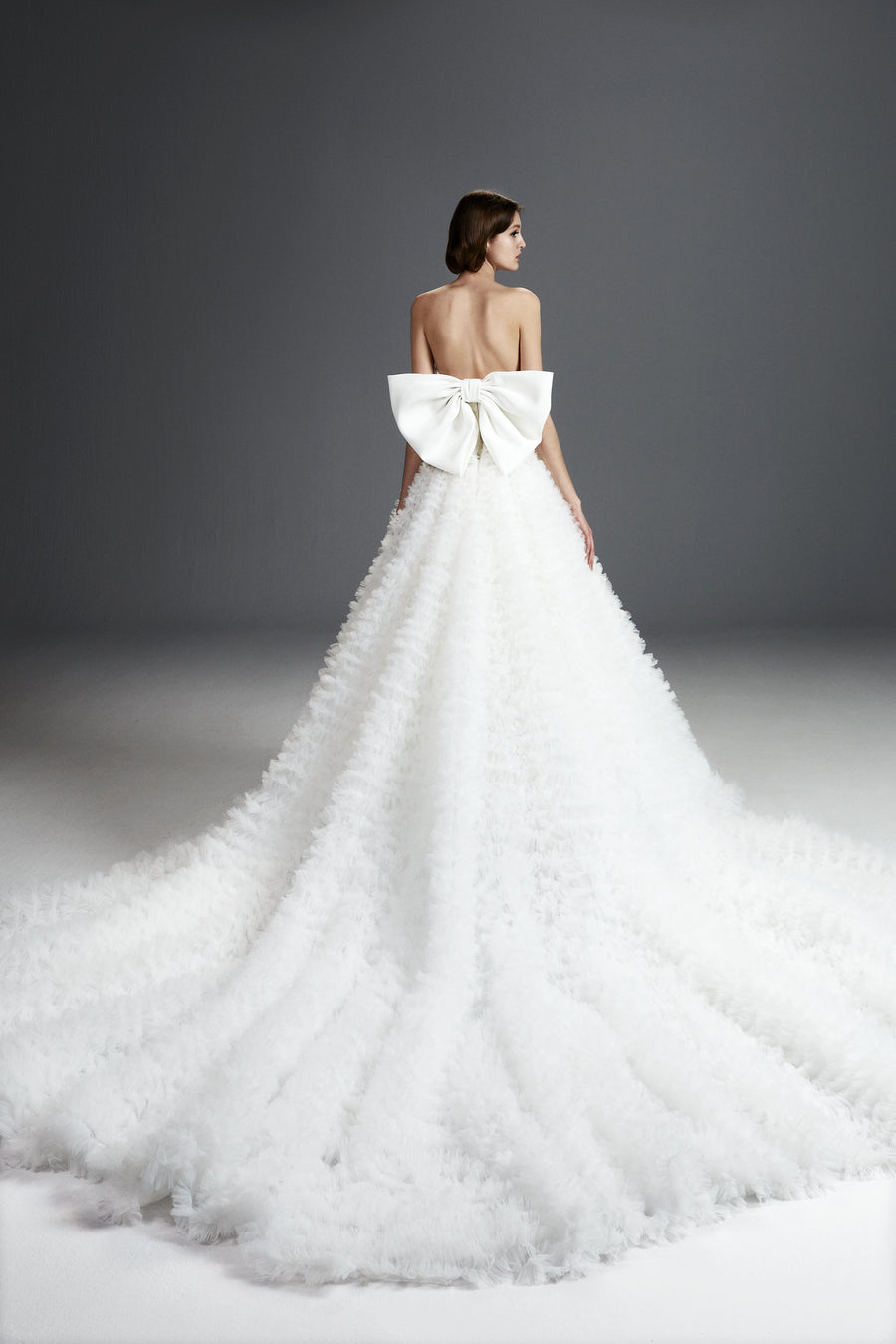 Viktor & Rolf Mariage Bridalwear Collection, Tulle ruffle gown featuring an elegant large bow, showcases couture elegance.