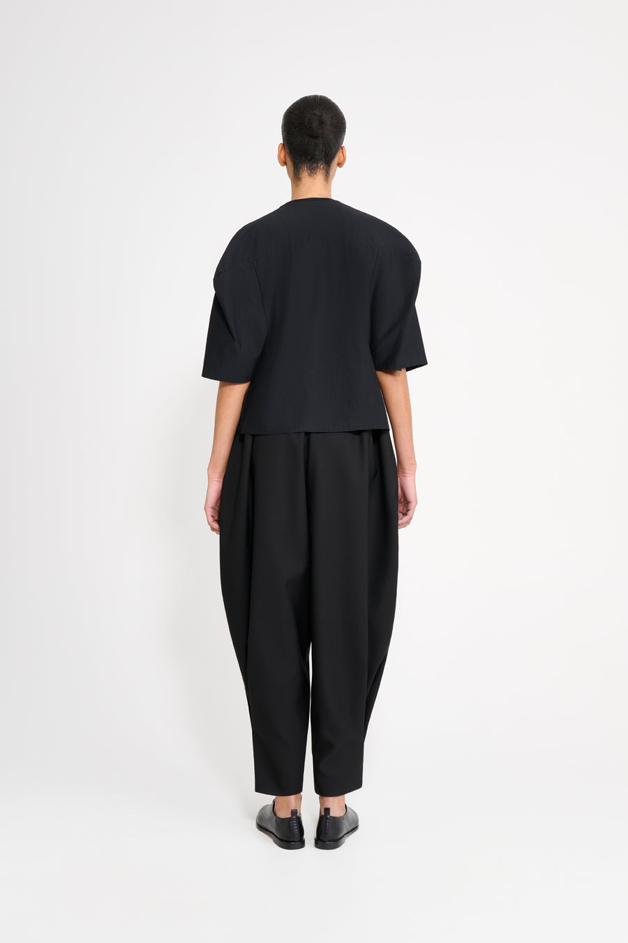 Person wearing a black outfit on a white background