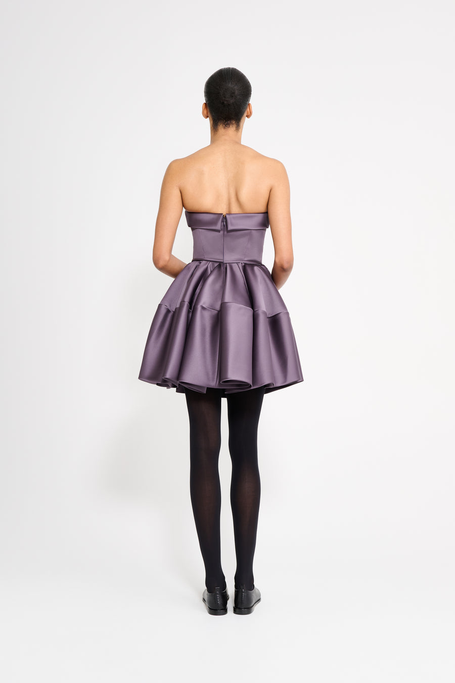 Model wearing a purple mini dress on a white background.