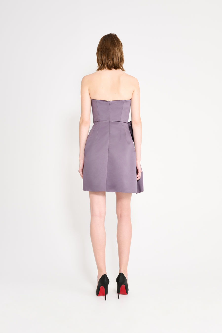 Model wearing a purple mini dress on a white background.