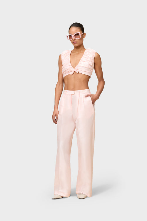 Model wearing a pink satin set on a white background.